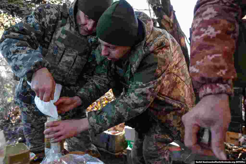 Хлопці пересипають цукор в скляну банку, ховаючи його від мишей