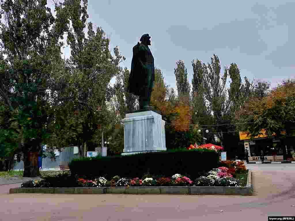 Різнобарвне листя на деревах і квіти на клумбі біля пам&#39;ятника Леніну в Феодосії &ndash; останні барви осені в Криму