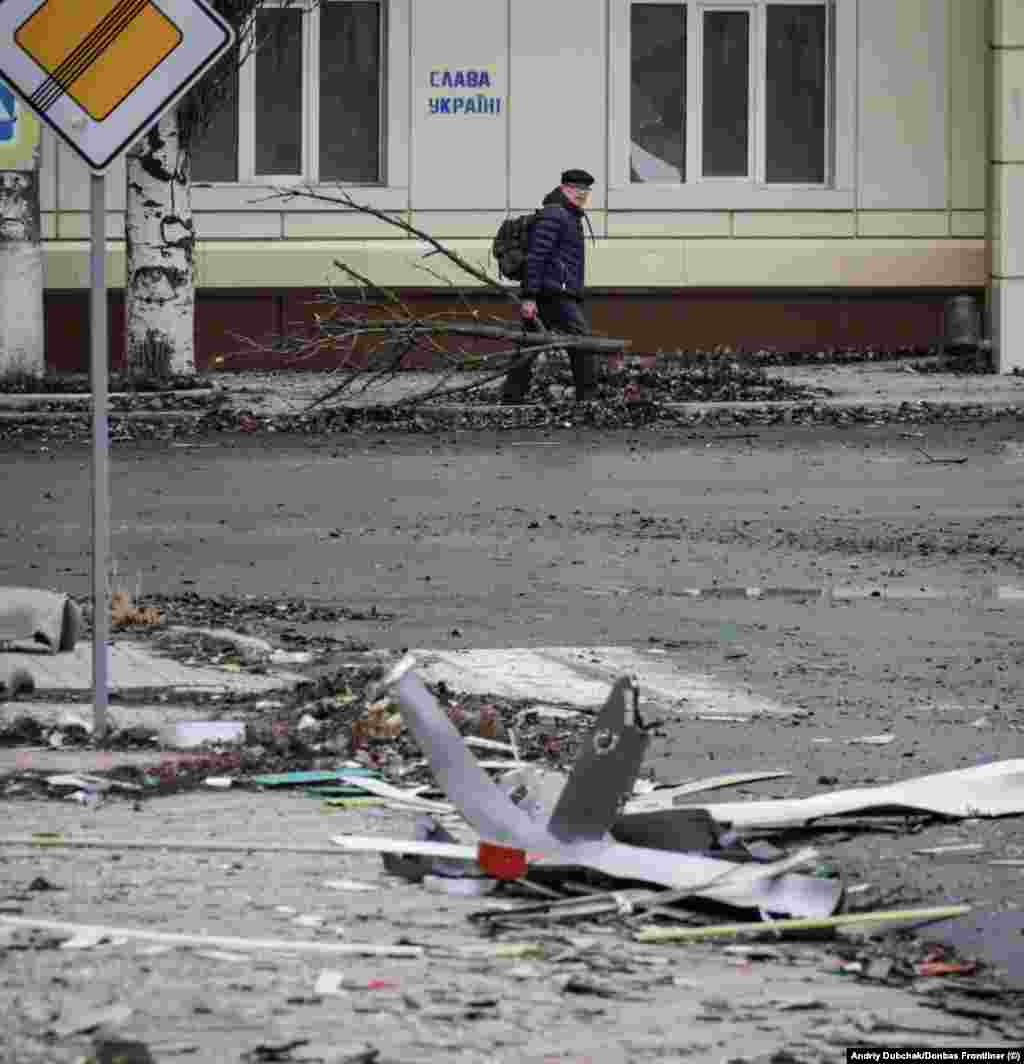 Чоловік несе гілки дерева, які використає на дрова. На стіні за ним графіті з написом &laquo;Слава Україні!&raquo; Андрій Дубчак каже, що жителі залишаються у місті з різних причин, враховуючи бажання захистити своє майно та страх перед тим, яким буде життя внутрішньо переміщеної особи. Деякі мирні жителі, за його словами, чекають приходу обіцяного кремлівською пропагандою &laquo;русского мира&raquo;