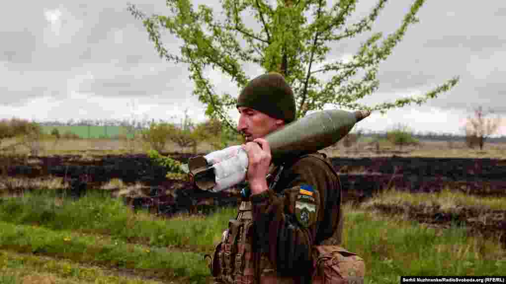 Український військовий несе мінометний снаряд на позиції, Харківська область, 9 травня 2022 року