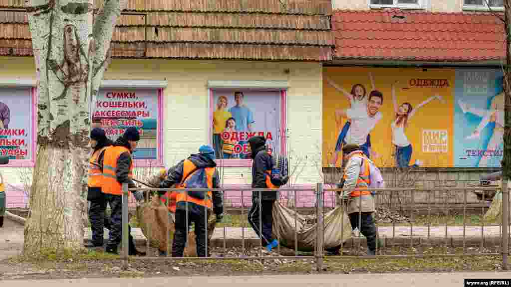 Комунальники прибирають торішнє листя на вулиці Генерала Захарова