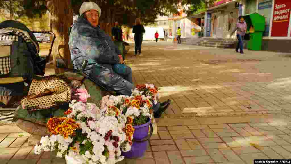 Пенсіонерка торгує хризантемами на вулиці Гайдара