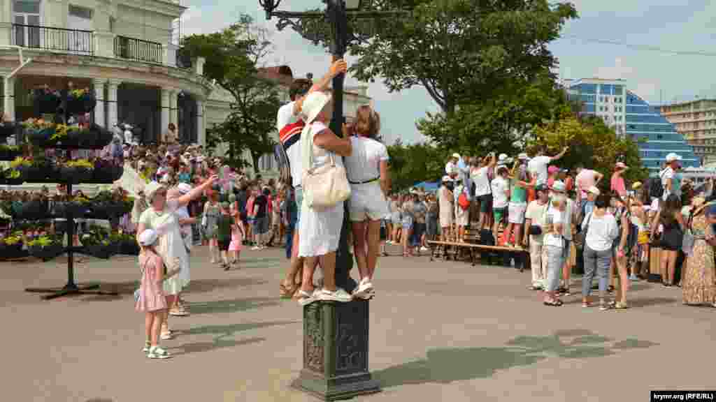 Люди залізли на ліхтар для кращого огляду