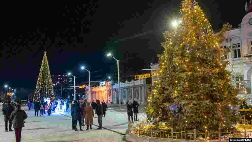 Вперше за 20 років цьогоріч на Театральній площі встановили штучну головну міську ялинку заввишки 11 метрів. Раніше головною тут була жива ялинка, яку також прикрасили (праворуч)