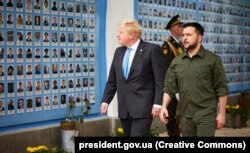 Президент України Володимир Зеленський і премʼєр-міністр Великої Британії Борис Джонсон (ліворуч) під час вшанування загиблих українських воїнів у війні з Росією біля Стіни пам'яті. Київ, 17 червня 2022 року