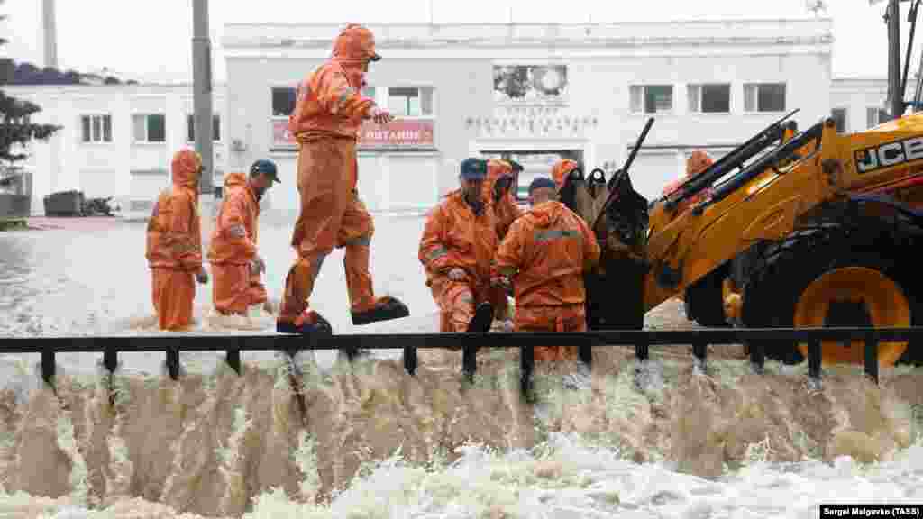 Співробітники російського МНС звільняють шлях для стоку води в річку Мелек-Чесмі на вулиці Маршала Єременка перед стадіоном імені 50-річчя Жовтня