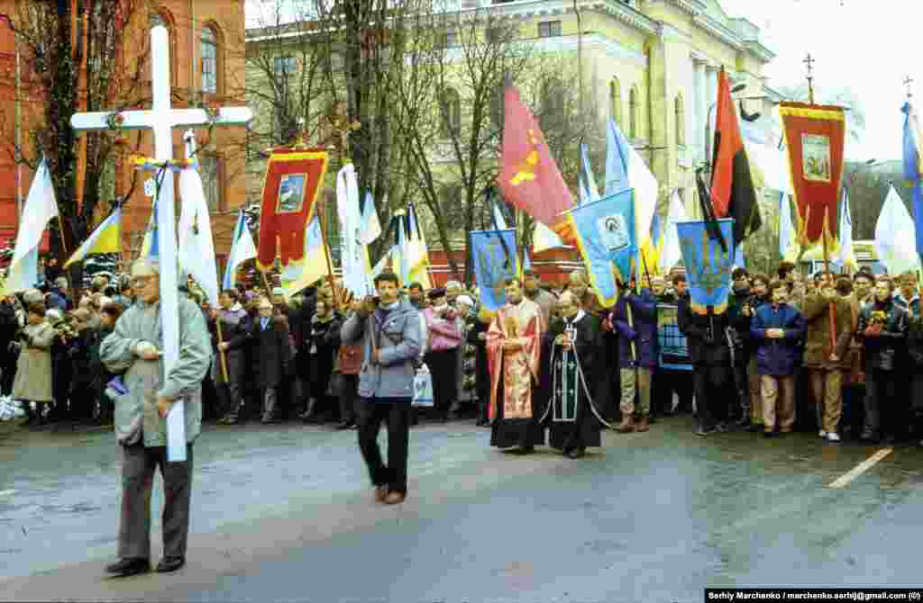 Учасники церемонії перепоховання підходять до червоного корпусу Київського національного університету імені Тараса Шевченка.&nbsp;Несе хрест &ndash; активіст УГС Олекса Миколишин