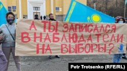 Алматыдағы наразылық митингісінде "Сайлауды бақылаушы болып жазылдың ба?" деген жазу ұстап тұрған адамдар. 31 қазан 2020 жыл.