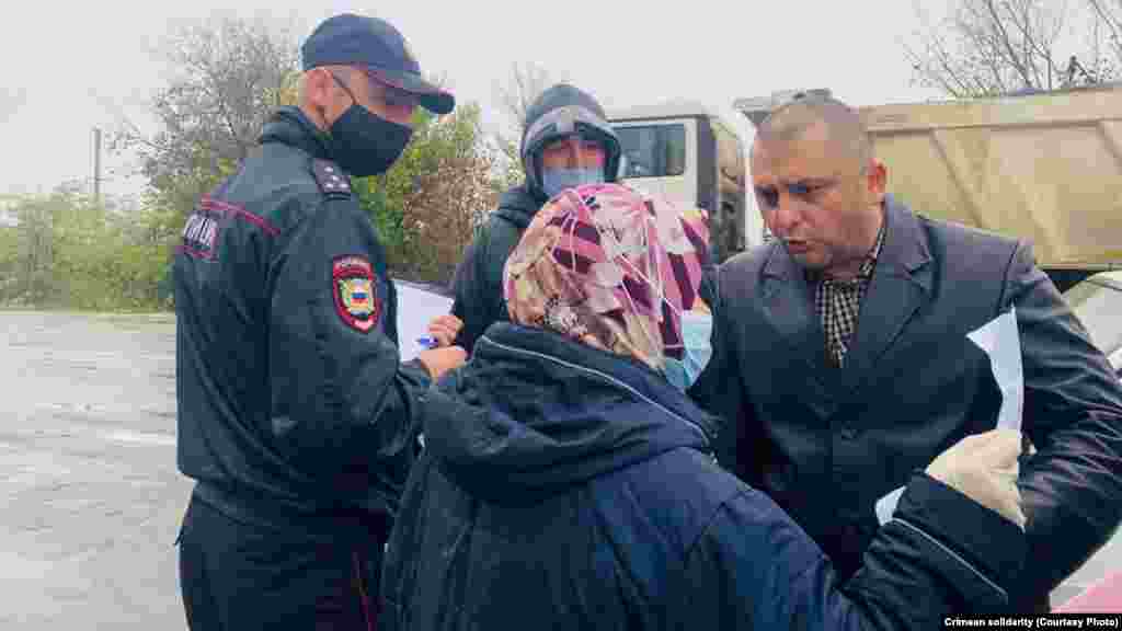 31 жовтня. Російський поліцейський зупиняє одиночний пікет Зуре Емірусеїнової &ndash; матері фігуранта красногвардійської &laquo;справи Хізб ут-Тахрір&raquo;. &nbsp; Загальна декларація прав людини та низка інших міжнародних документів гарантують кожному право на свободу зібрань, у тому числі з метою мирного протесту. Тоді жінка вийшла на одиночний пікет із плакатом &laquo;Мій син &ndash; не терорист&raquo;. У жінки вилучили плакат і склали на неї протокол, визнавши її пікет &laquo;мітингом&raquo;. &nbsp; Представники міжнародної ісламської політичної організації &laquo;Хізб ут-Тахрір&raquo; називають своєю місією об&#39;єднання всіх мусульманських країн в ісламському халіфаті, але відкидають терористичні методи досягнення цього. Захисники заарештованих і засуджених у &laquo;справі Хізб ут-Тахрір&raquo; кримчан вважають їх переслідування мотивованим за релігійною ознакою. Ця організація заборонена і визнана терористичною в Росії, але не в Україні