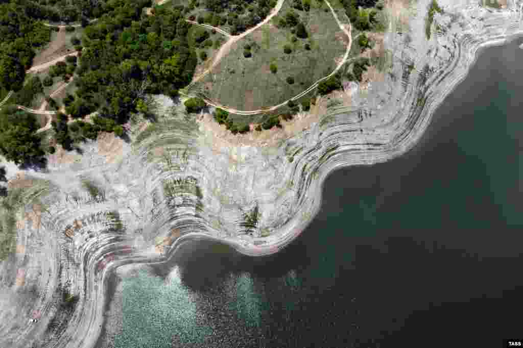 Краєвид згори на обміліле Сімферопольське водосховище. Такий краєвид фотографи зафіксували три тижні тому, 3 червня 2020 року