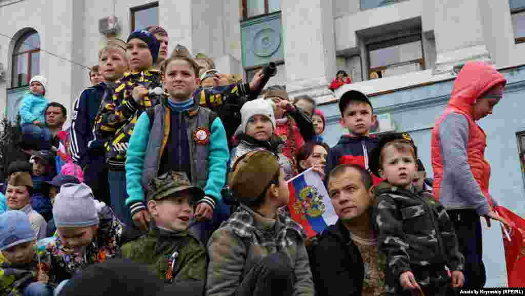 9 травня 2019, Сімферополь. Діти спостерігають за парадом військової техніки в центрі міста. Для кращого огляду вони піднялися на виставлений біля будівлі кримського парламенту танк