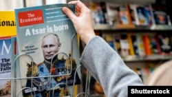 Жінка купує в газетному кіоску журнал The Economist із зображенням на обкладинці президента Росії Володимира Путіна із заголовком «Народився цар». Франція, Страсбург, 28 жовтня 2017 року