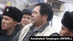 Полицейлер Алматыдағы "Сарыарқа" кинотеатрының сыртындағы алаңда өткен оппозицияның наразылық акциясынан белсенді Ермек Нарымбаевты әкетіп бара жатыр. 2010 жылғы 30 қаңтарда түсірілген фото.