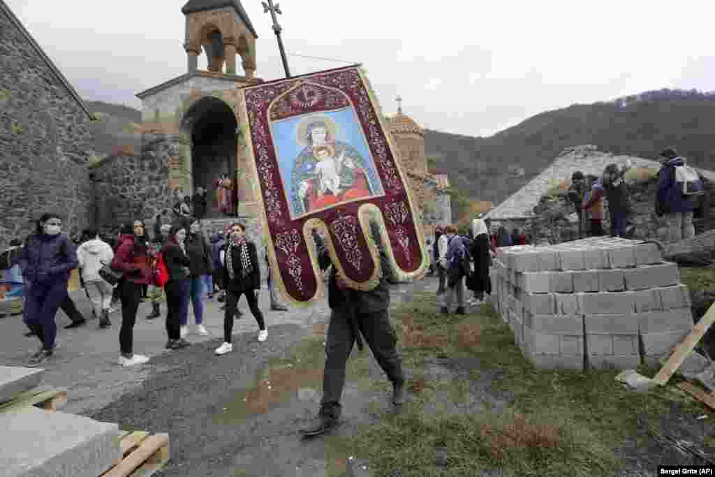 Армян шіркеуінің қызметшісі Кельбаджар ауданындағы Дадиванк монастрінің діни жалауын алып бара жатыр.