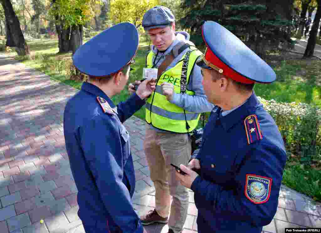 Ашық жасыл және қызғылт түсті жилет киіп, оқиғадан ақпарат таратқан журналистерге формадағылар келіп, қызметтік куәліктерін тексерді, телефондарын суретке түсіріп алды. Суретте полицейлер фототілші Владимир Третьяковтың қызметтік куәлігін тексеріп жатыр.&nbsp;&nbsp;